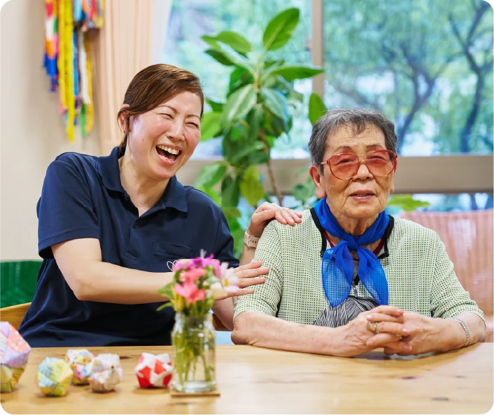 仲田富枝さんの肩に手を置く笑顔の中瀬千春さん