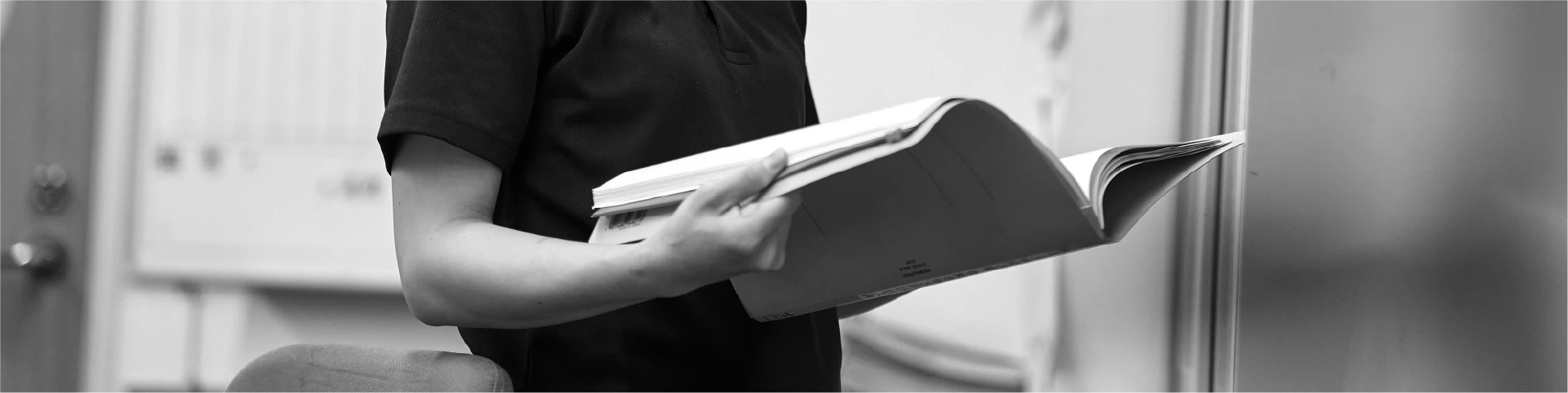 資料を見る職員のモノクロ写真